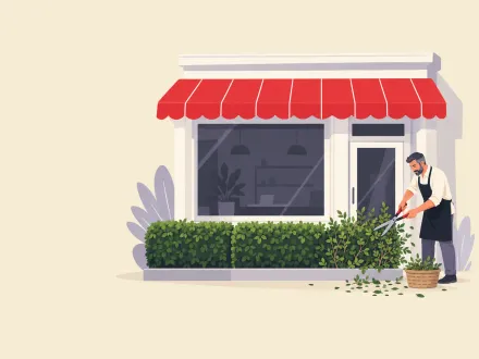 A shop owner trims an overgrown section of the hedge along his shop front with long shears.