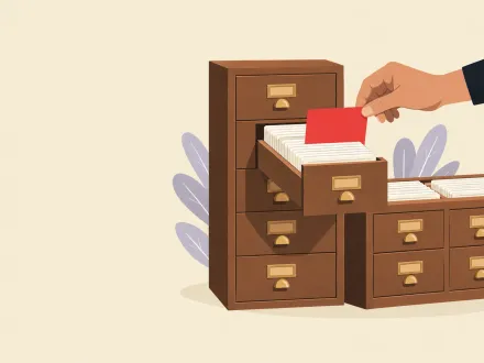 Two card-catalogue cabinets of different shapes, one drawer open and a hand lifting out a single red card.