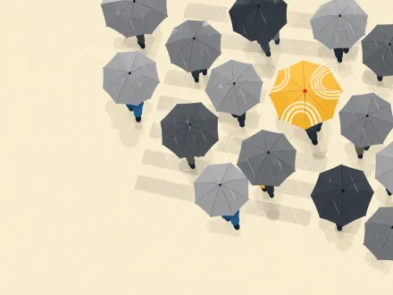 A crowd of grey umbrellas seen from above, with one yellow umbrella standing out