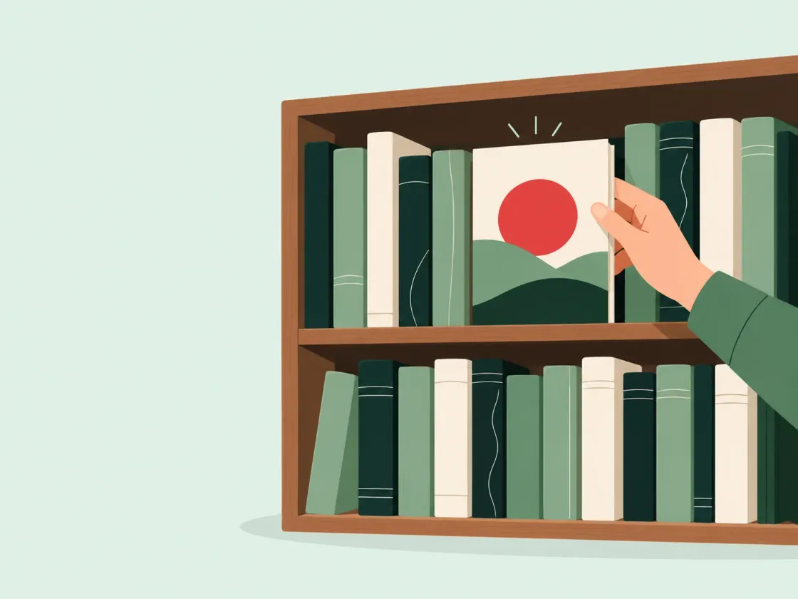 A hand pulls out the one book turned face-out among rows of spines on a bookshelf, its cover showing a red sun.