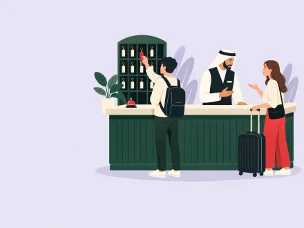 At a hotel front desk a guest takes a key from a self-service rack while a staff member talks with another guest.